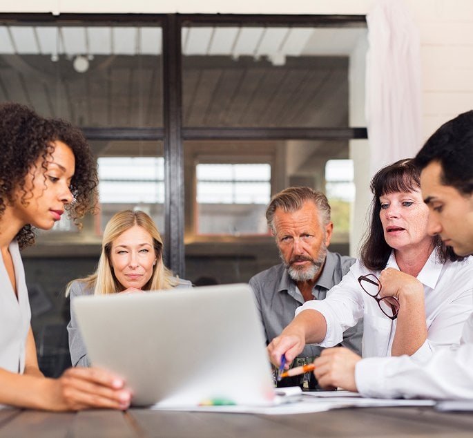 Equipo de profesionales analizando información en una reunión, enfocándose en la búsqueda de talento.